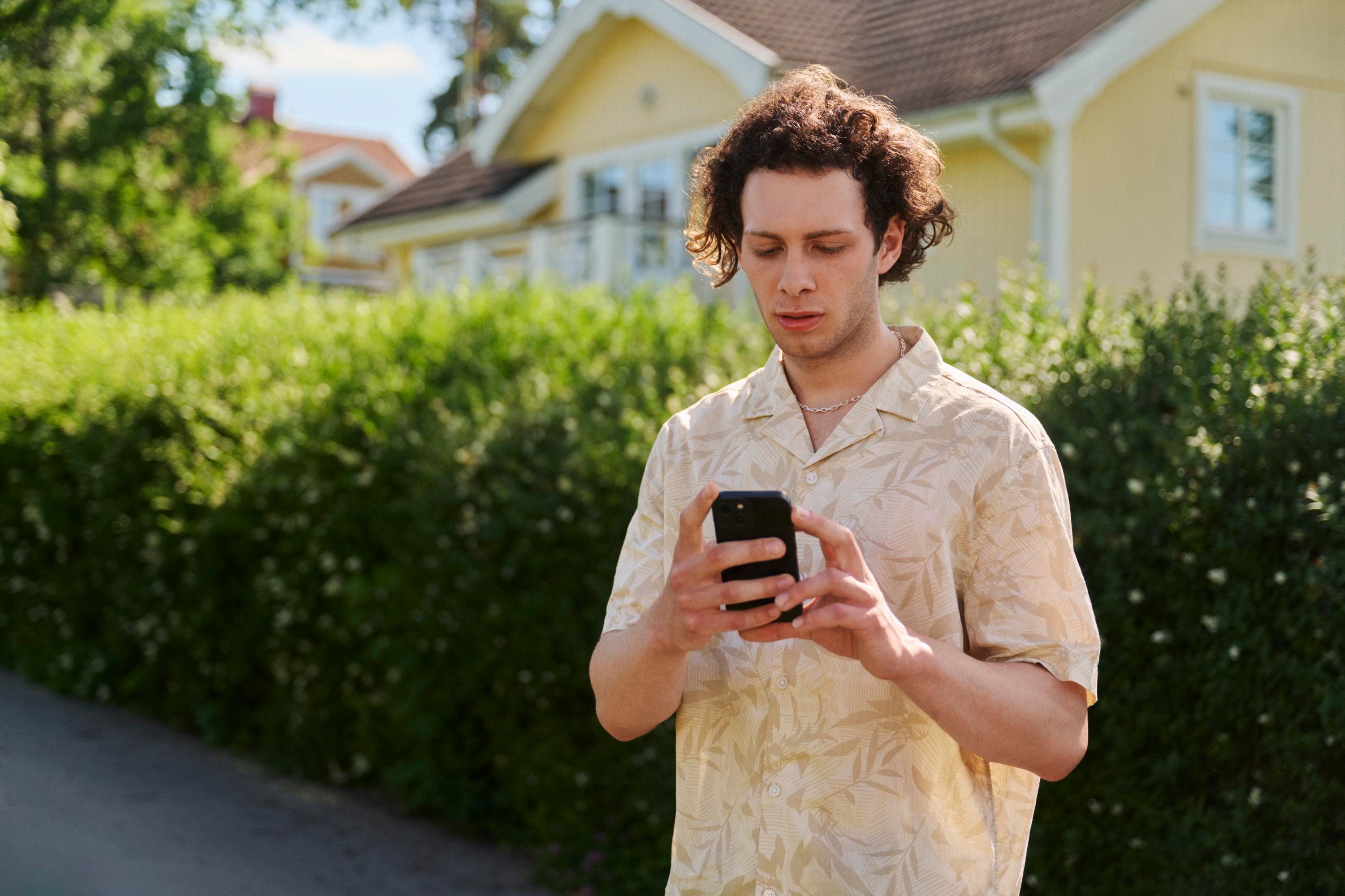 Ung man tittar i sin mobil