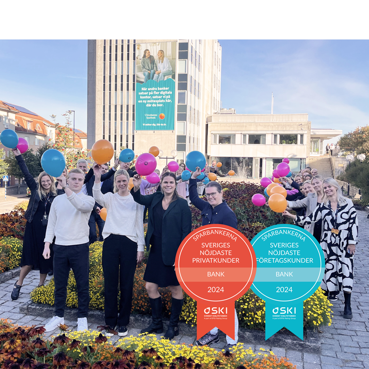 Personer står framför en bankbyggnad och viftar med ballonger